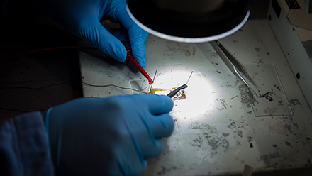 Close up of gloved hands working in a lab