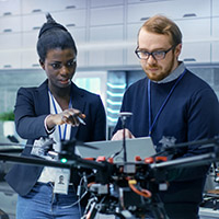 Two people talking in front of lab equipment