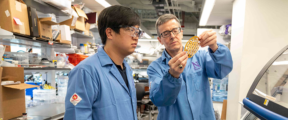 Two people examining object in lab