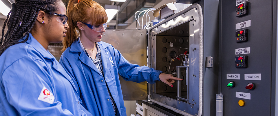 Two students in a lab observing an experiment