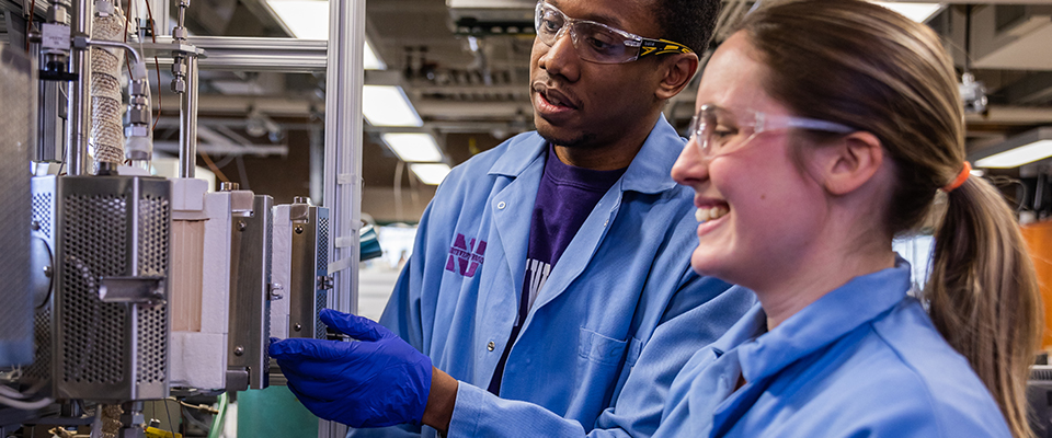 Two students in a lab observing an experiment