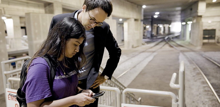 Professor and student study data on a device