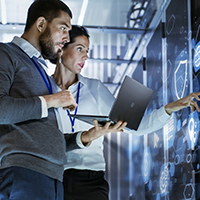 A man and woman pointing at a computer screen