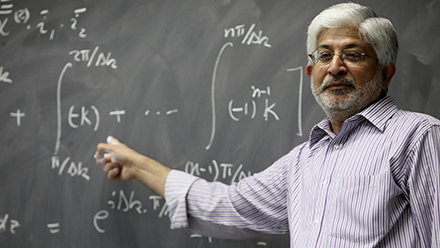 Prem Kumar teaching in front of a chalk board