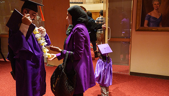 With a potential future graduate in the background, a graduate meets a supporter following the ceremony.